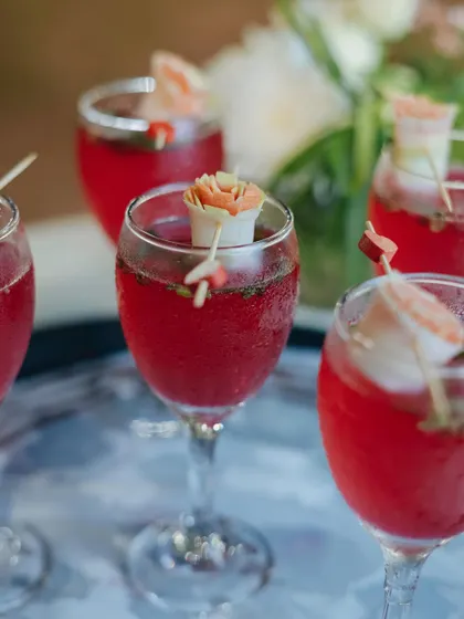 Raising a glass to unforgettable moments. These beautiful red mocktails, garnished with delicate edible flowers, add a touch of elegance to any grand event.
