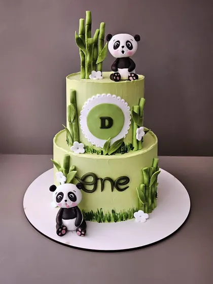 A grand panda-themed cake for Baby D's first birthday. This 3kg, two-tier butterscotch cake features adorable fondant pandas and bamboo details, perfect for a big celebration.