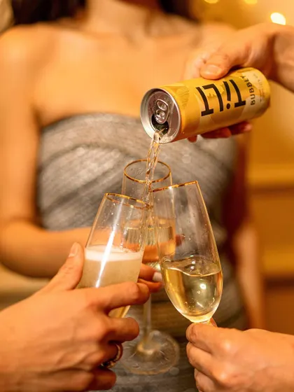 An action shot of Tilt wine being poured into champagne flutes. This image elevates the canned wine by associating it with classic celebration rituals, blending convenience with sophistication.