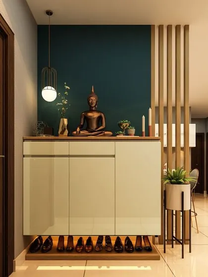 A foyer should make a lasting impression. This elegant design features a shoe cabinet with a Buddha statue for a serene welcome, a dark teal accent wall, and a wooden slat partition.