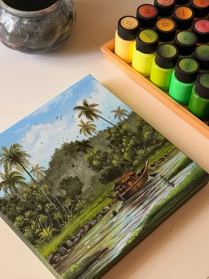 The finished Kerala backwaters painting on my desk, next to the green and yellow paints I used.