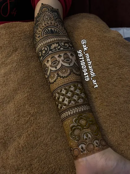 A full view of the arm, showcasing the different bands of patterns, including jaal, vines, and bells.