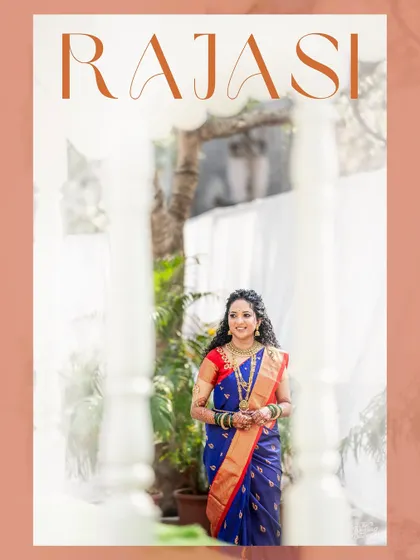 A beautiful portrait of a Maharashtrian bride in a traditional blue saree, framed by white pillars. A picture of classic elegance and grace.
