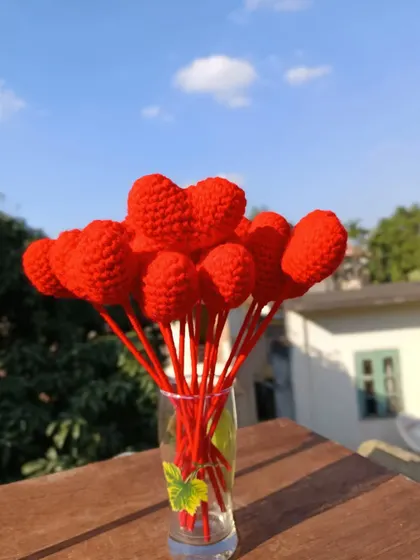 A vase full of red heart flower stems.