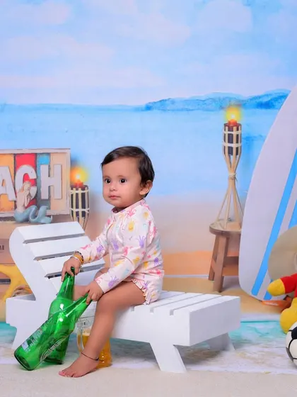 Our 'Beach Baby' theme brings the shore to the studio. I use a beach-themed backdrop, a miniature deck chair, a surfboard, and other fun props to create a sunny and playful setting for your child.