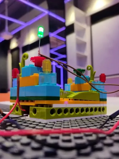 A student's creation of a smart building with an LED light, a project combining building with basic electronics.