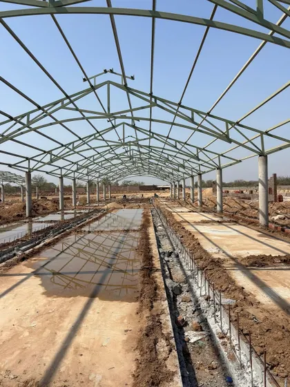 **Sanctuary in Shade, Gandhinagar:** A work-in-progress shot of an expansive refuge for cattle. The steel truss structure is designed to provide maximum shade and ventilation, showing our work extends to large-scale, functional infrastructure.