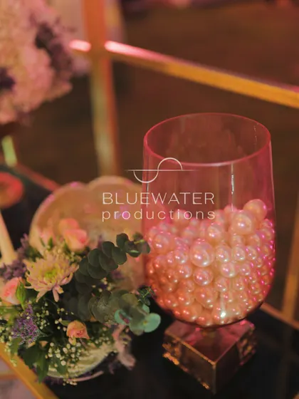 A simple yet elegant detail: a glass vase filled with pearls sits next to a small floral arrangement.