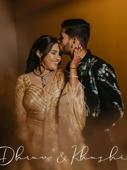 A tender moment between the couple, with the groom kissing the bride's forehead. The soft, dreamy effect adds to the romance of this Sangeet night portrait.
