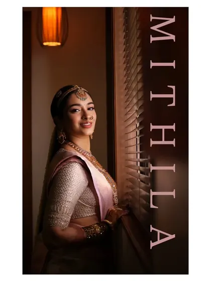 A beautifully composed shot of Mithila by the window. The natural light highlights the flawless finish of her makeup and the intricate details of her traditional South Indian bridal attire.