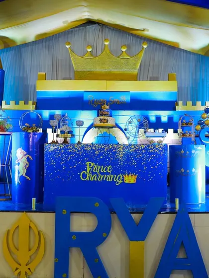 A royal kingdom for Prince Ryan's first birthday. This grand castle stage features bold blue and gold colors, a large personalized name display, and charming prince props for a truly regal celebration.
