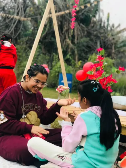Two friends sharing a happy moment at a picnic table during a birthday celebration.
