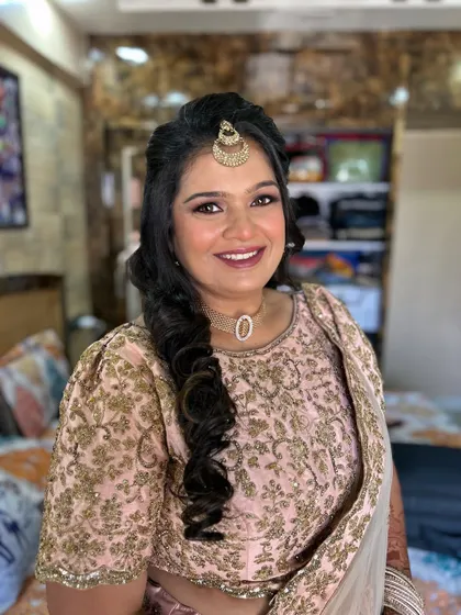 A smiling portrait showing her complete look. The soft curls and glowing makeup make her look radiant.