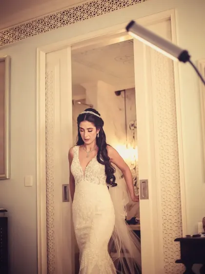 A bride in her white gown, captured as she walks through a doorway.
