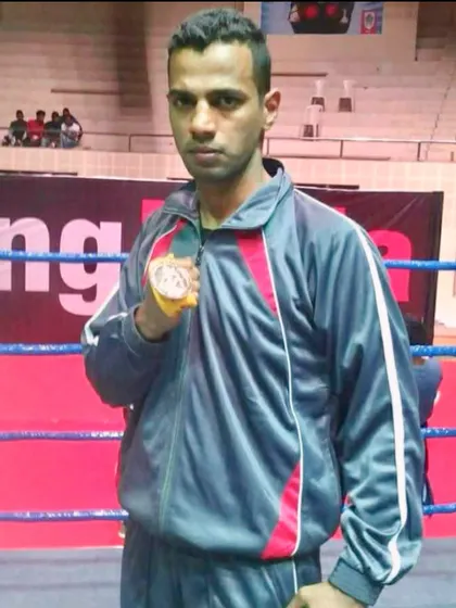 Holding a medal inside the ring. This is my home. I have earned my place here, and I help my students earn theirs.