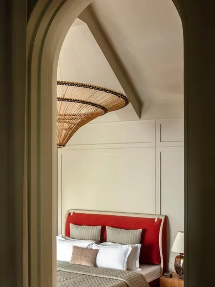 A glimpse into the master bedroom of Summer Haus from the Elle Decor cover story. The arched doorway frames the view, creating a sense of anticipation and discovery.