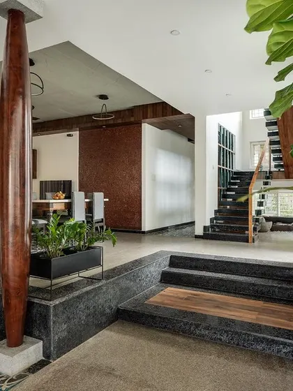 I used the natural slope of the land to create interesting level changes within the house. This view shows the transition from the main living area to other zones, defined by steps and a change in flooring material from concrete to stone.