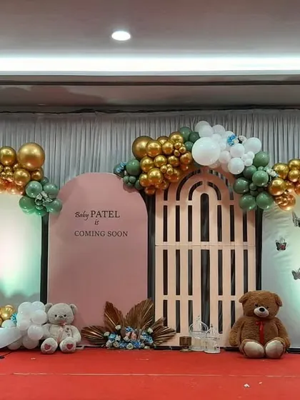 A whimsical baby shower theme with a crescent moon, teddy bears, and a garden gate prop. The sage green, gold, and white color scheme is both elegant and playful.