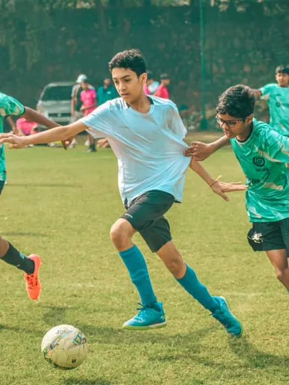 A player shields the ball while teammates provide support.