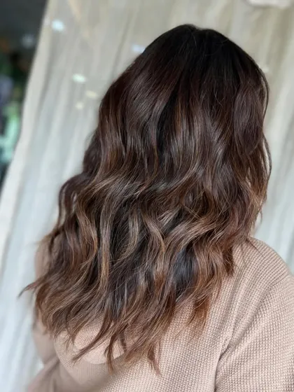 A glossy brown mane that brings all the sass. This look is styled into soft, beachy waves for an effortlessly cool vibe.
