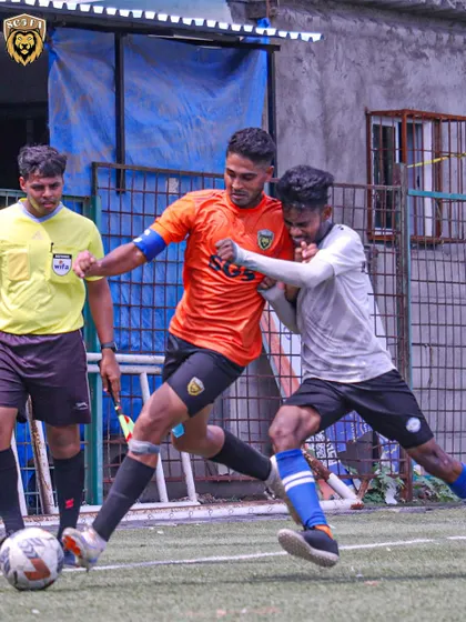 An intense moment as our player shields the ball from a tough challenge right in front of the referee.