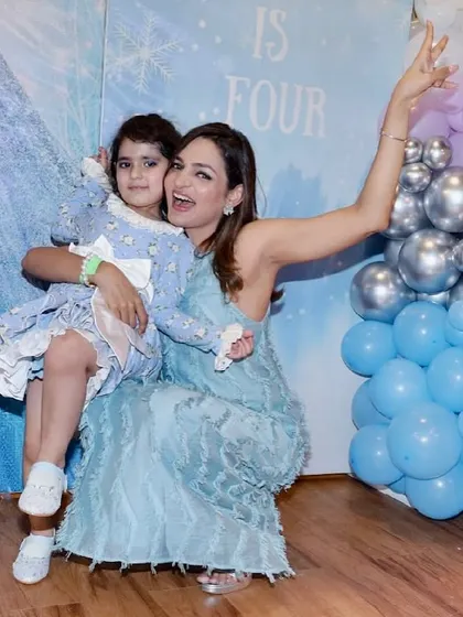 The birthday girl and a guest share a happy moment at the Frozen-themed celebration.