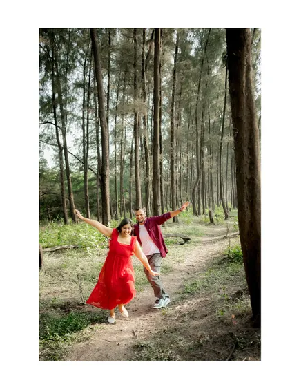 A fun, dynamic shot of a couple dancing playfully on a path in the woods. This pre-wedding photo captures their joyful and energetic personalities.