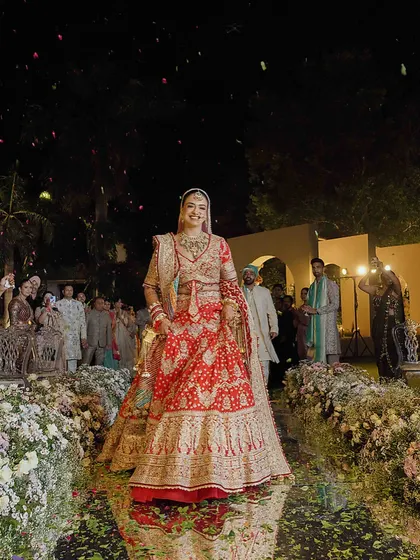 The bridal entry is a moment everyone waits for. Here, she walks down a path of flowers, looking absolutely radiant in her Rimple and Harpreet lehenga.