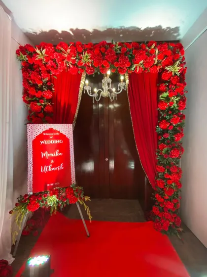 The perfect welcome to a classic Indian wedding. This entrance is framed by a thick arch of red flowers, with red drapes and a red carpet leading guests into the celebration.