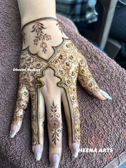This elegant Arabic-inspired design features delicate vines and leaves, creating a beautiful flow across the hand. It's a perfect choice for someone wanting a non-traditional look.