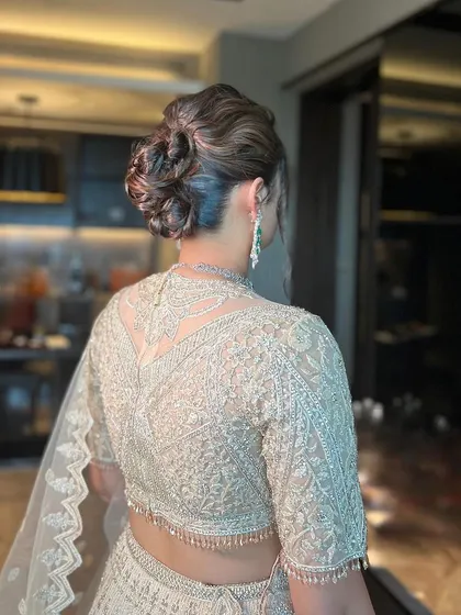 The finished messy bun, a stylish and contemporary choice for a modern bride.
