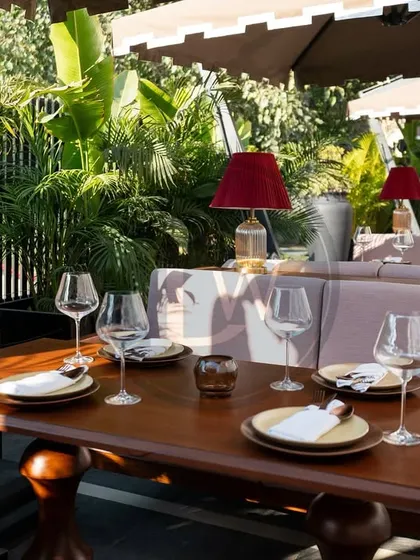 The outdoor seating at Addonis, featuring our custom-made dining tables and cushioned banquettes. The rich wood tones and plush fabrics create a warm and inviting al fresco dining experience.