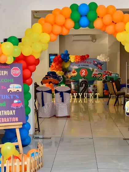 Welcome to the party! This 'Wheels on the Bus' themed entrance features a colorful balloon arch and a custom welcome sign, setting a fun and exciting tone for the celebration right from the start.