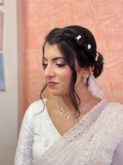 A closer look at the intricate braid and floral details of this Christian bride's hairstyle. The soft tendrils frame her face beautifully.