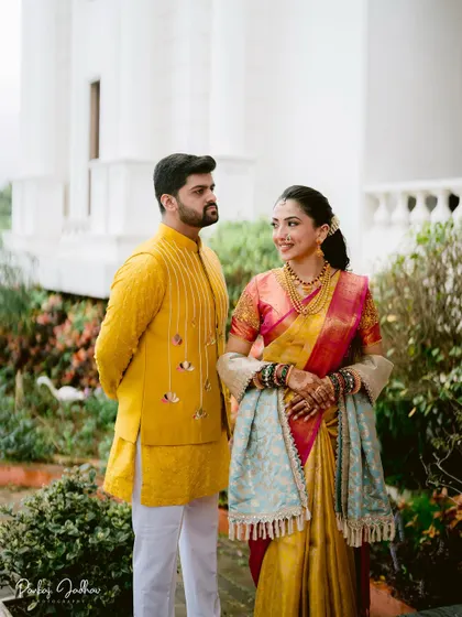 Maithili and Dhruv in a classic portrait, their traditional attire shining against the elegant backdrop.
