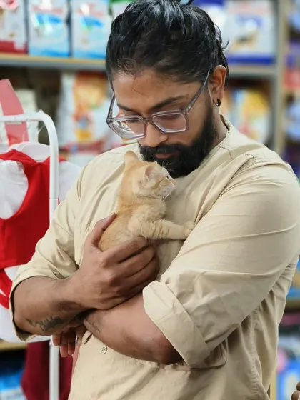 A moment of quiet connection between a visitor and a tiny kitten. Sometimes, the quietest moments are the most meaningful.