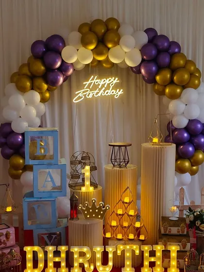 This elegant setup with purple, gold, and white balloons, along with various props and marquee letters, is part of our premium affordable packages.