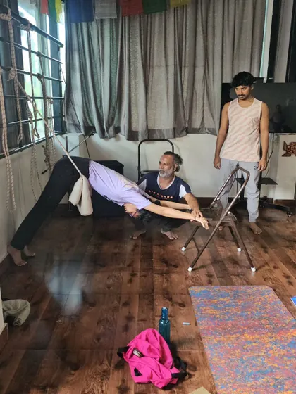 Using a chair and ropes to explore a variation of Downward-Facing Dog, this setup allows for a therapeutic release of the spine.