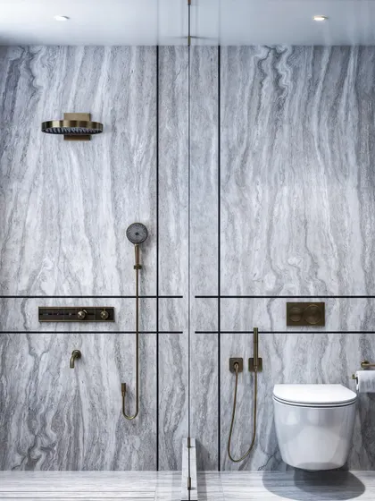 A master washroom featuring cool-toned grey marble throughout. The render focuses on the clean, linear design and the sophisticated brass fixtures.