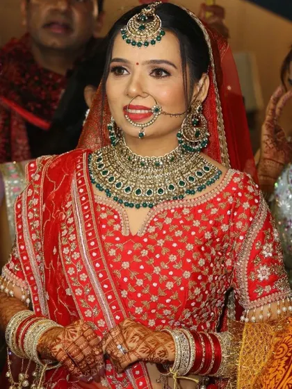 A close-up of the bride's happy expression. The makeup features a classic red lip and defined eyes, perfect for a traditional wedding.