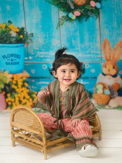 A bright and cheerful indoor setup. This Easter-themed backdrop with vibrant blues and yellows creates a happy and colorful setting for a baby's portrait.