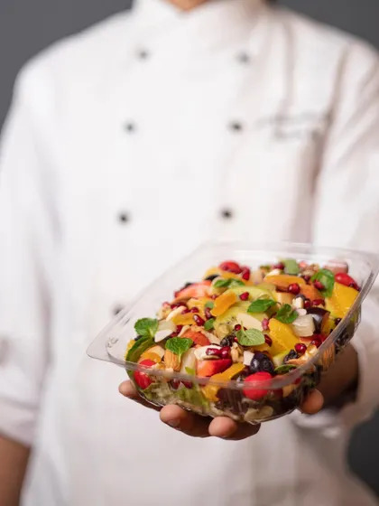 Meet our visionary founder, a culinary maestro who infuses every dish with love and patience. This image shows him holding one of our fresh fruit salad bowls.