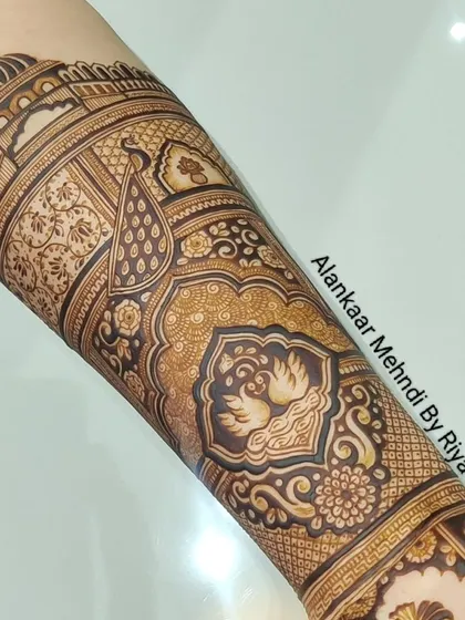 A completed arm piece featuring swans and peacocks within ornate, traditional frames.