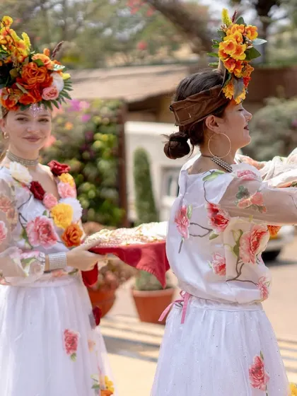 Hostesses in floral-themed outfits welcome guests to the Mehendi. The costumes of the hospitality staff are also designed to match the event's theme, ensuring a fully immersive experience.
