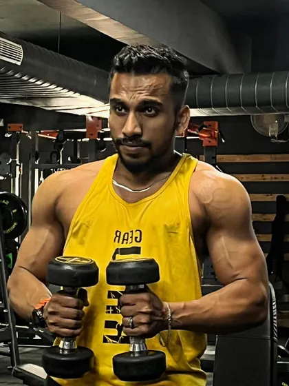 Holding a pair of dumbbells, ready for a set of bicep curls. This is where the work happens. Every single workout is a step towards becoming great.