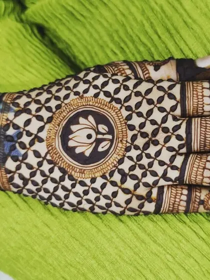 A striking back-hand design with a lotus-themed check pattern covering the hand. The wrist cuff features a bold, shaded lotus, creating a beautiful contrast in styles.