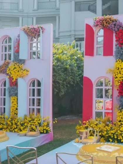 A 'Rang Rang Mein' themed Haldi, celebrating all the colors of life. The decor features multi-colored windows as a backdrop, surrounded by bright, playful floral arrangements.