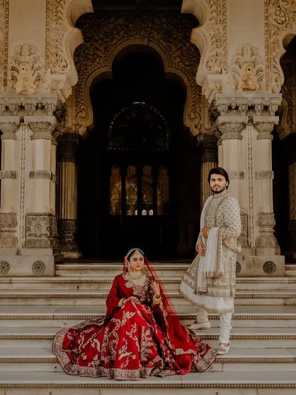 A majestic portrait of the couple on the steps of the Laxmi Vilas Palace in Baroda.