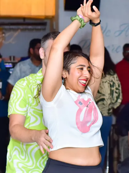 A joyful, arms-up moment of celebration on the dance floor.