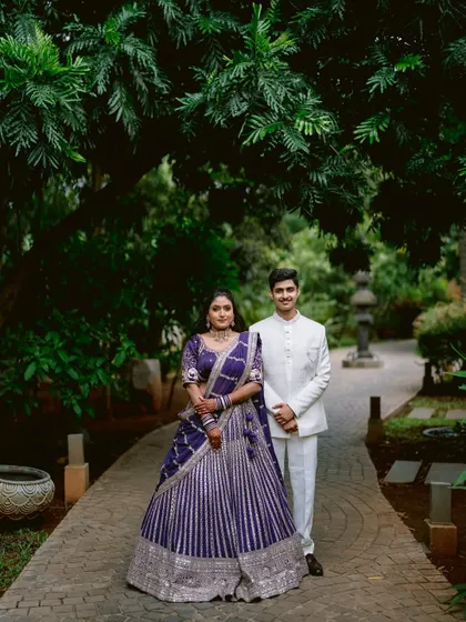 A grand portrait of Apeksha and Rutwij in their stunning purple and white engagement outfits.